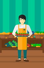 Image showing Supermarket worker with box full of apples.