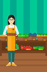 Image showing Supermarket worker with box full of apples.