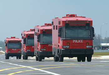 Image showing Four red police trucks