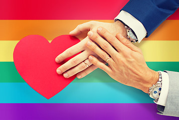 Image showing close up of male gay couple hands with red heart