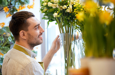 Image showing happy smiling florist man at flower shop