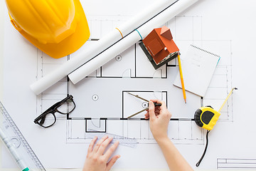 Image showing close up of hands with compass measuring blueprint