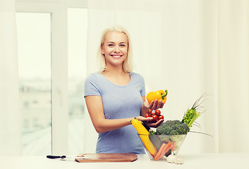 Image showing smiling young woman cooking vegetables at home