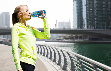 Image showing woman drinking water after doing sports outdoors