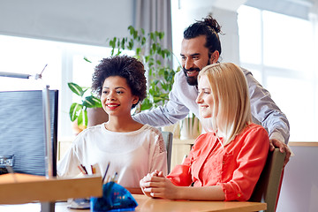 Image showing happy creative team with computer in office