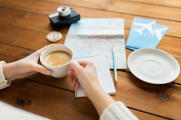 Image showing close up of hands with coffee cup and travel stuff