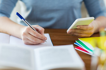 Image showing close up of student with smartphone and notebook