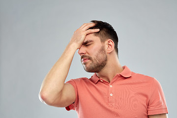 Image showing unhappy man suffering from head ache