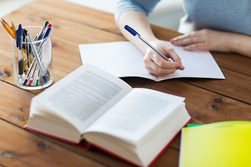 Image showing close up of student with book and notebook at home