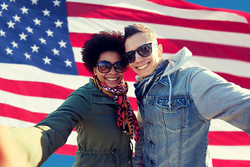 Image showing happy couple taking selfie over american flag