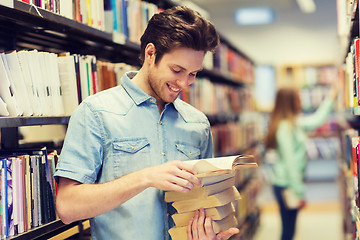 Image showing happy student or man with book in library