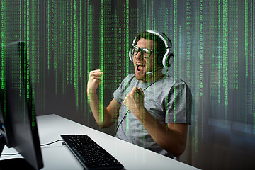 Image showing man in headset playing computer video game at home