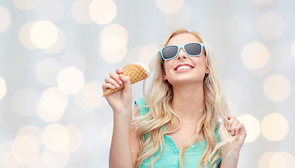 Image showing happy young woman in sunglasses eating ice cream