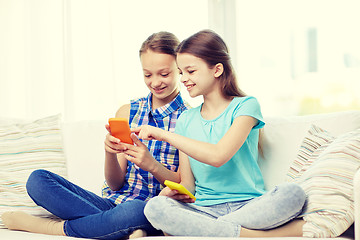 Image showing happy girls with smartphones sitting on sofa