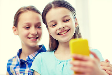 Image showing happy girls with smartphone taking selfie at home