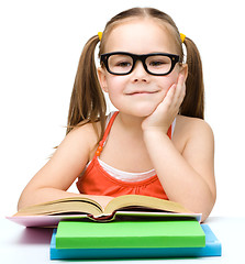 Image showing Little girl is reading a book