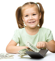 Image showing Little girl is counting dollars