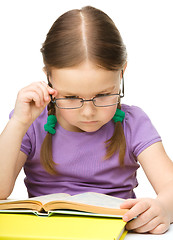 Image showing Little girl is reading a book