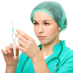 Image showing Young nurse is preparing syringe for injection