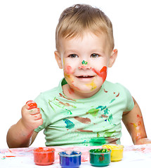 Image showing Little boy is playing with paints