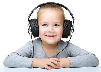 Image showing Little girl is enjoying music using headphones