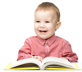 Image showing Little child play with book