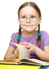 Image showing Little girl is reading a book