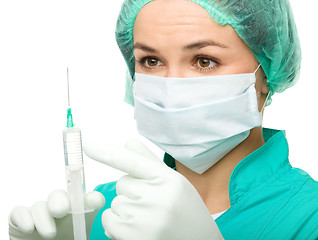 Image showing Young nurse is preparing syringe for injection