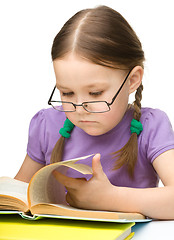 Image showing Little girl is reading a book