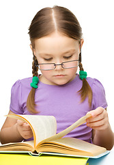 Image showing Little girl is reading a book