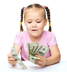 Image showing Little girl is counting dollars