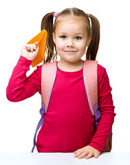 Image showing Schoolgirl with backpack throwing a paper airplane