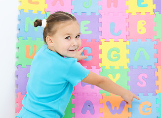 Image showing Little girl is pointing at letter G on alphabet