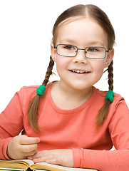 Image showing Little girl is reading a book