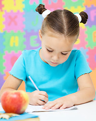 Image showing Little girl is writing using a pen