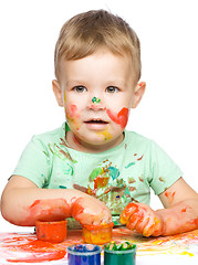 Image showing Little boy is playing with paints