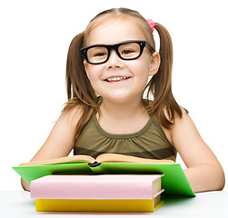 Image showing Little girl is reading a book