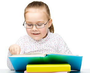 Image showing Little girl is reading a book