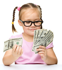 Image showing Little girl is counting dollars