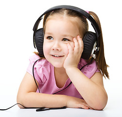 Image showing Cute little girl enjoying music using headphones