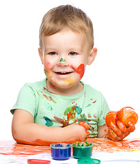 Image showing Little boy is playing with paints