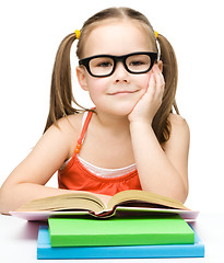 Image showing Little girl is reading a book