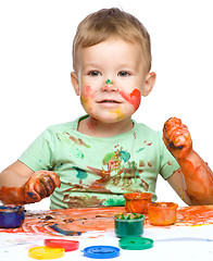 Image showing Little boy is playing with paints