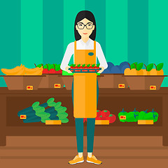 Image showing Supermarket worker with box full of apples.