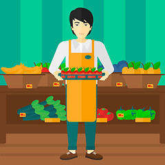 Image showing Supermarket worker with box full of apples.