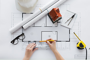 Image showing close up of hands with ruler measuring blueprint