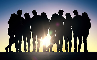 Image showing silhouettes of friends sitting on stairs over sun