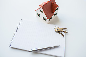 Image showing close up of home model, house keys and notebook