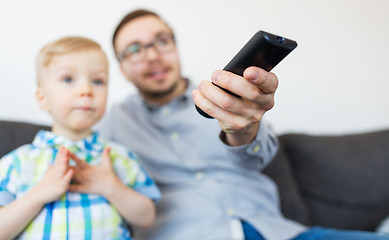 Image showing father and son with remote watching tv at home