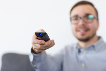 Image showing smiling man with tv remote control at home